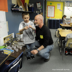 LAKEWOOD, CO - APRIL 15: Reg Cox, the senior minister for Lakewood Church of Christ, talks with Tony Sandoval, 7, about his clay project at Foothills Elementary School on April 15, 2014, in Lakewood, Colorado. Cox helps organize the Whiz Kids after-school project at the school and brings volunteers from his church and the surrounding neighborhood to tutor disadvantaged students. Cox says of the program, "The attention tutors give kids is dramatic; it could be the key to (the student's) academic transformation." (Photo by Anya Semenoff/The Denver Post)
