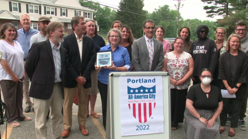 The Portland team poses with their 2022 All-America City Award plaque. the plaque was presented by the League's former president, Chris Gates. 